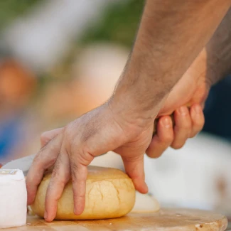 Mão cortando queijo